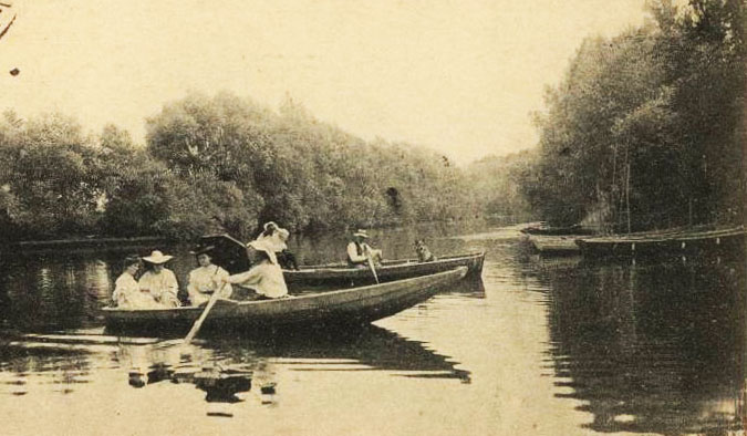 Femmes élégantes dans une barque avec une ombrelle.